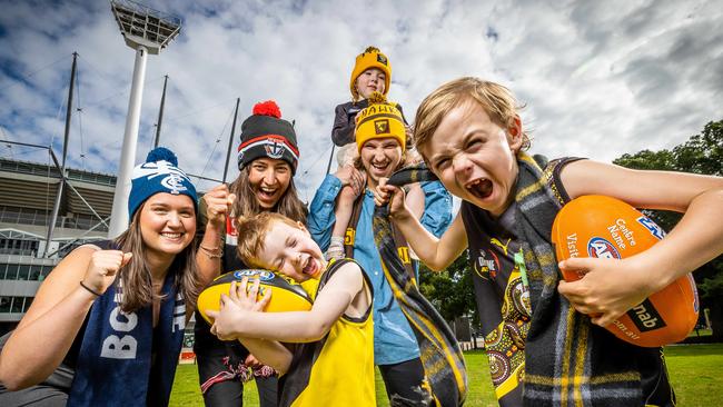 (L-R) Maddie Barras, Charlotte Godley and Tom Ryan are joined by kids Rosie, 3, Max, 5, and Jack, 7, celebrate news that the cost of footy tickets will be frozen for 2023. Picture: Jake Nowakowski