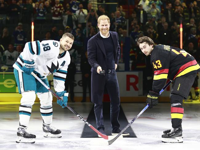 VANCOUVER, CANADA - NOVEMBER 20: Quinn Hughes #43 of the Vancouver Canucks and Tomas Hertl #48 of the San Jose Sharks take part in a ceremonial faceoff with Prince Harry, Duke of Sussex before their NHL game at Rogers Arena on November 20, 2023 in Vancouver, British Columbia, Canada.  (Photo by Jeff Vinnick/NHLI via Getty Images)