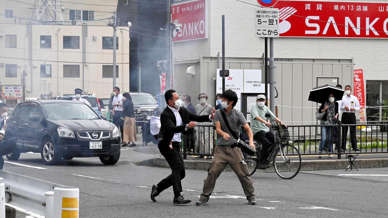 Tetsuya Yamagami being tackled to the ground by police at Yamato Saidaiji Station in the city of Nara. Picture: Getty Images