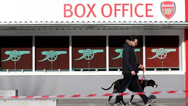 A pedestrian walks his dog outside the Emirates Stadium in London. There has been no Premier League football played since March 9. Picture: AFP