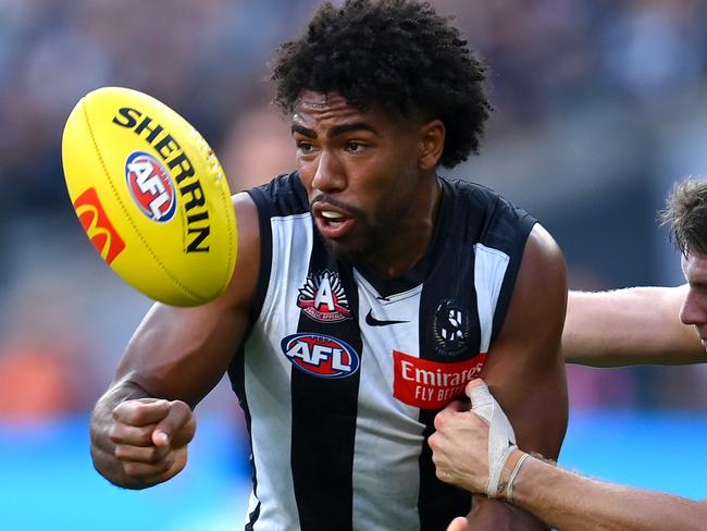 MELBOURNE, AUSTRALIA - APRIL 25: Isaac Quaynor of the Magpies handballs whilst being tackled by Jye Menzie of the Bombers during the round six AFL match between Collingwood Magpies and Essendon Bombers at Melbourne Cricket Ground, on April 25, 2023, in Melbourne, Australia. (Photo by Quinn Rooney/Getty Images)