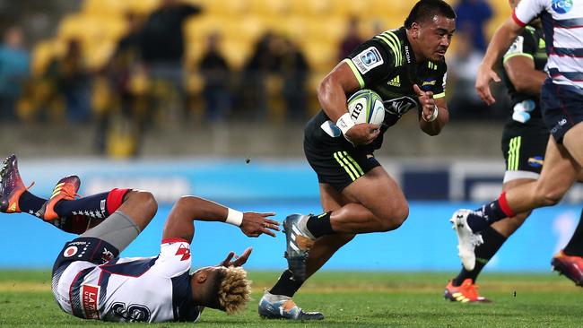 Asafo Aumua of the Hurricanes runs over Will Genia of the Rebels.