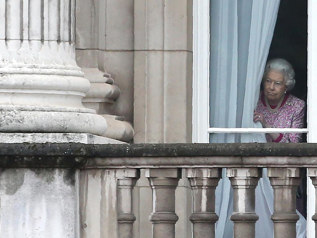 Queen Elizabeth II looks out from Buckingham Palace as guests gather for the Patron's Lunch. Picture: AFP