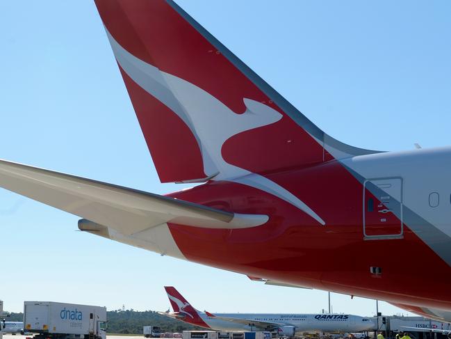 Catering vans pass a QANTAS Boeing 787 Dreamliner at Melbourne Airport. Picture: Andrew Henshaw
