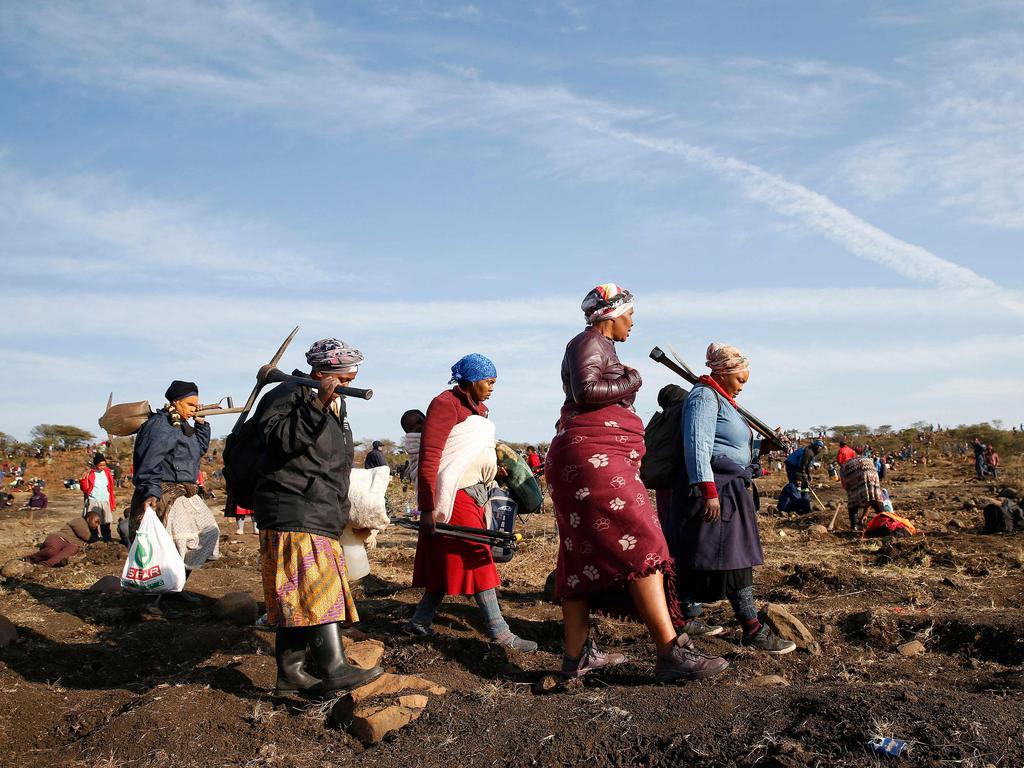 A group of women call it a day after hours spent digging for diamonds. Picture: Phill Magakoe/AFP