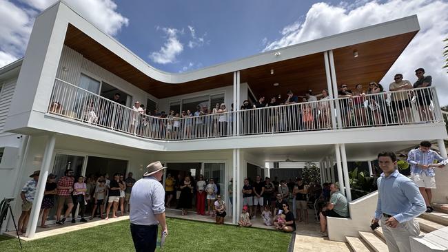 More than 70 people are visible in this shot alone, completely packing the deluxe house as it was auctioned off.