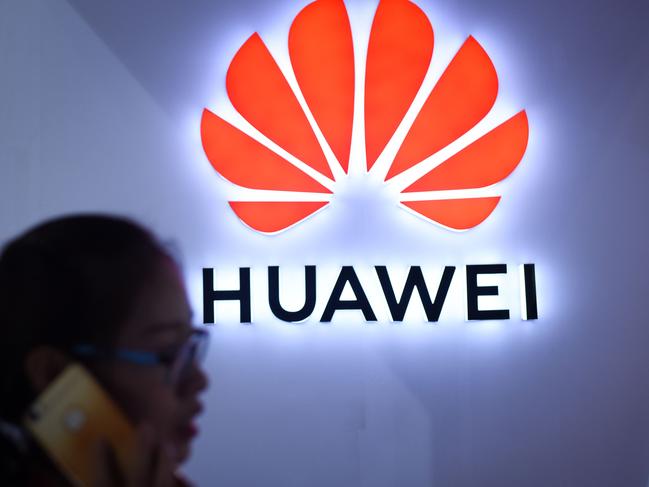 (FILES) This file picture taken on July 9, 2018 shows a woman using her mobile phone in front of a LED display board of Huawei at Beijing International Consumer Electronics Expo in Beijing.  Despite being essentially barred from the critical US market, Huawei surpassed Apple to become the world's number two smartphone maker in the second quarter of this year and has market leader Samsung in its sights. Huawei has achieved this in part by refocusing away from the futile fight for US access and toward gobbling up market share in developing nations with its moderately priced but increasingly sophisticated phones, analysts said. / AFP PHOTO / WANG Zhao / TO GO WITH China-telecommunication-Huawei-mobile-Samsung-Apple, FOCUS by Dan Martin