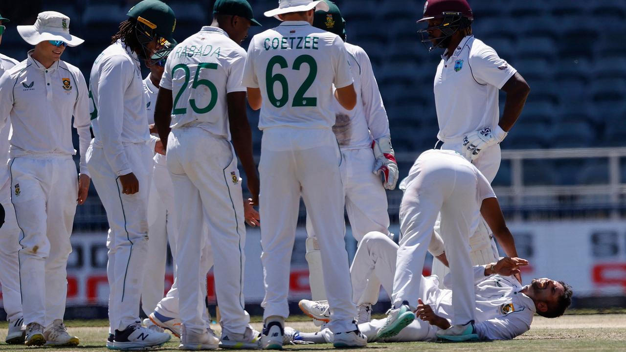 Temba Bavuma (3rd R) tends to Keshav Maharaj (R) after he injured himself while celebrating. (Photo by PHILL MAGAKOE / AFP)