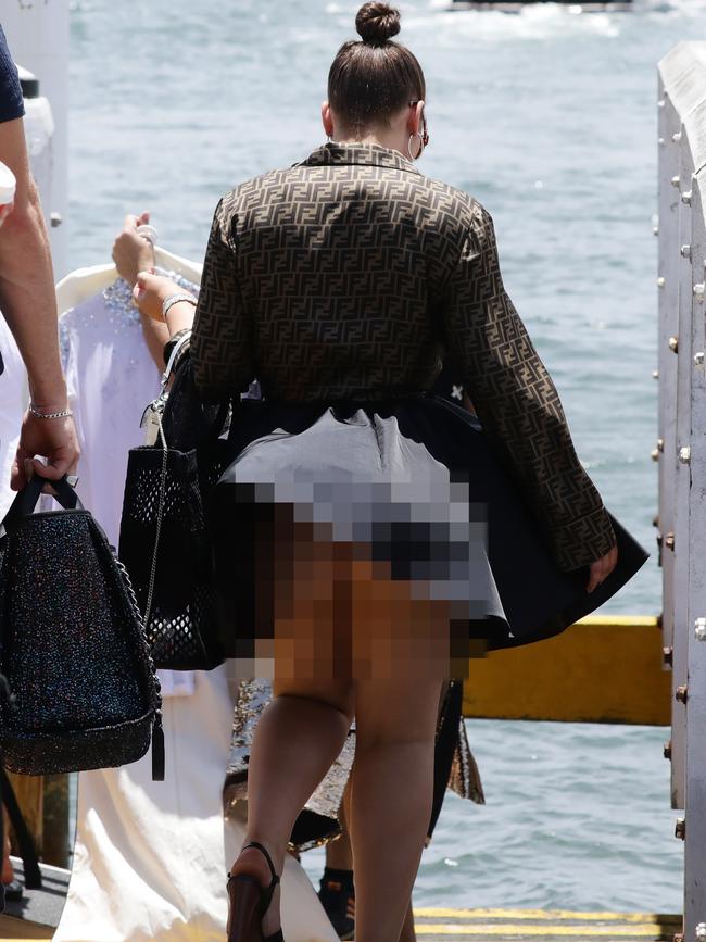 A gust of wind throws Francesca Packer’s frock into the air as she prepares to board a tender boat with a friend at Double Bay. Pictures: Matrix Media