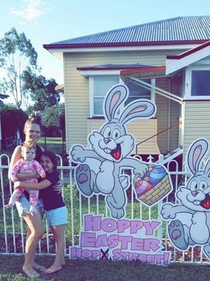 Stevie Brennan with Ava McGregor and Ruby Brennan take photos with the sign made by the Burt family.