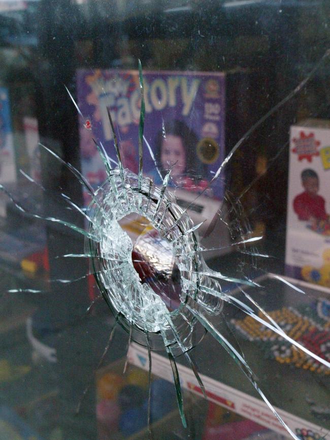 A bullet hole in a shop window from the shooting of Thompson.