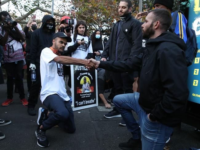 Paul Silver (left) takes a knee with a man he believes is an undercover police officer. Picture: David Swift