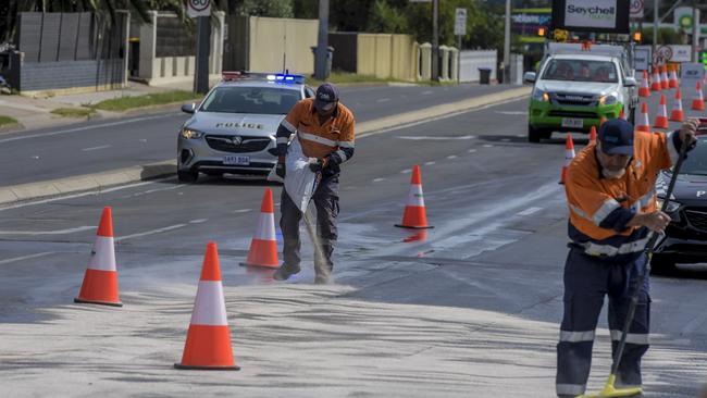 Workers cleaning up the oil spill on Tapleys Hill Road. Photo: Roy VanDerVegt.