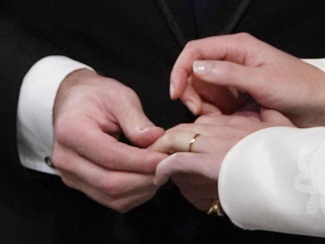 Jack Brooksbank places the ring on the finger of his bride Princess Eugenie. Picture: AP