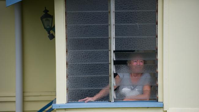 A concerned resident peers out her window in the flood hit suburb of Rocklea on Wednesday, January 12, 2011.
