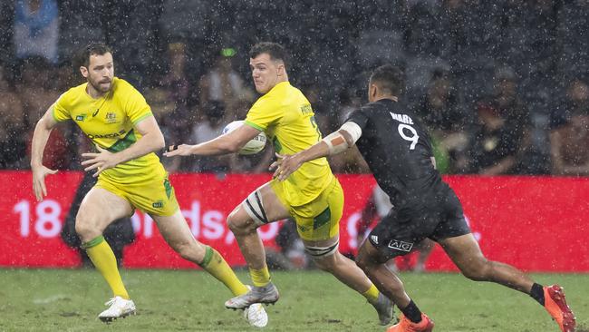 Dylan Pietsch (centre) charges past a New Zealand player while representing Australia in rugby sevens. Picture: AAP Image/Craig Golding