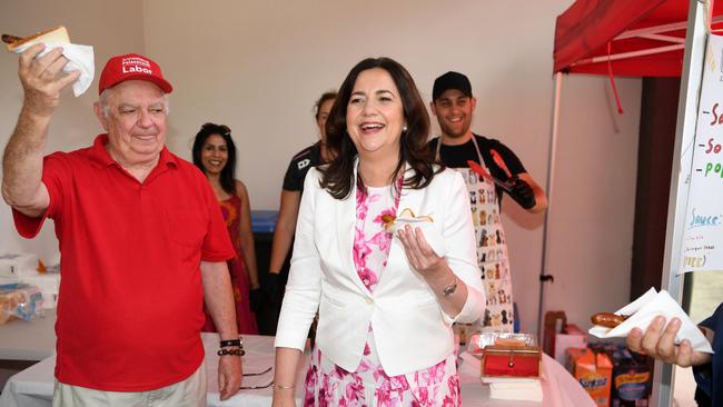 Queensland Premier Annastacia Palaszczuk and her father Henry Palaszczuk enjoy a Democracy Sausage after she cast her vote in the 2020 state election at Inala State School. Picture: NCA NewsWire / Dan Peled