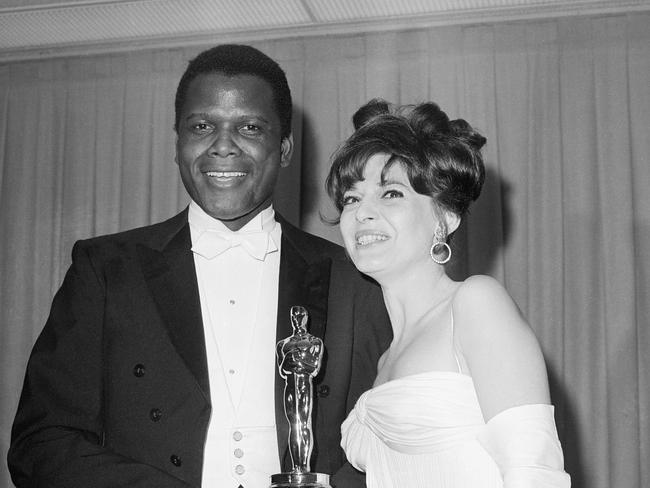 Sidney Poitier receives an Oscar presented by Anne Bancroft in Santa Monica, California, on April 13, 1964. He won Best Performance by an Actor for his role in the 1963 film Lilies of the Field.