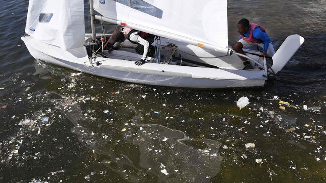 Garbage litters the water as sailors prepare for a training session at Rio de Janeiro’s Guanabara Bay.