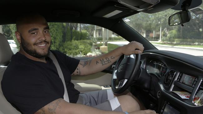 Miami Dolphins defensive lineman A.J. Francis poses inside his vehicle after an NFL football organized team activity, Monday, June 8, 2015, in Davie, Fla. Francis wants to help the Dolphins make the playoffs, but this offseason he has other destinations in mind-he's working as an Uber driver. (AP Photo/Lynne Sladky)