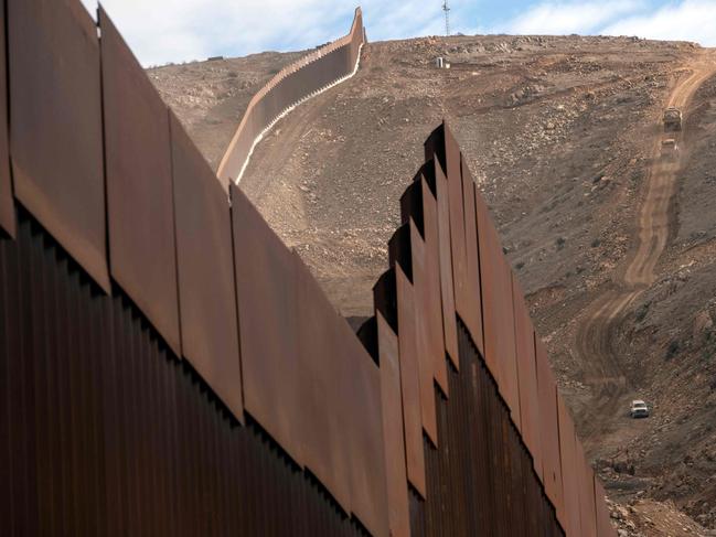 Construction crews work on a new section of the US-Mexico border wall. The fate of the wall is now up in the air. Picture: AFP