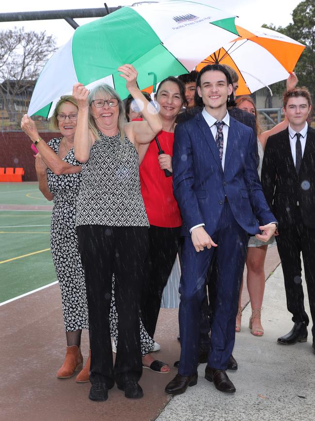 Pacific Pines High formal, at the school. Staff and students take cover from the weather. Picture Glenn Hampson