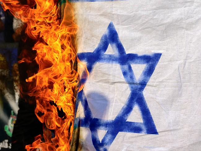 Demonstrators burn a homemade Israeli flag following the assassination of Lebanon's Hezbollah leader Sheikh Hassan Nasrallah, during a protest rally in the front of Israeli Consulate in Istanbul on September 29, 2024. People protested in Istanbul after the Iran-backed group Hezbollah party confirmed on September 28, that its longtime chief Hassan Nasrallah had been killed by an Israeli air strike on Beirut's southern suburbs on September 27. (Photo by Yasin AKGUL / AFP)