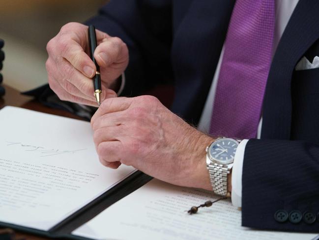 US President Joe Biden signs executive orders as part of the Covid-19 response in the State Dining Room of the White House in Washington, DC, on January 21, 2021. (Photo by MANDEL NGAN / AFP)