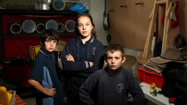 Kinglake West Primary School students Sonny, Camryn and Cohen in the music room that was hit by thieves three times. Picture: Hamish Blair