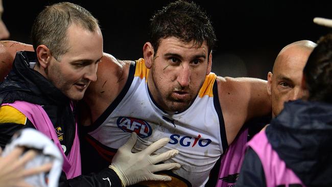 Eagle Dean Cox helped off the ground. Picture: Daniel Wilkins