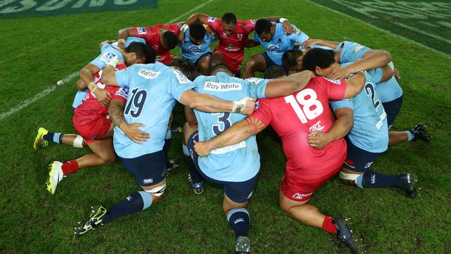 Reds and Waratahs players pray together in 2014. Picture: Darren England.