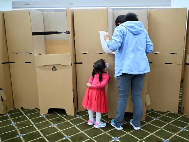 A young girl watches her mother as she casts her vote at a polling booth on May 21, 2022 in Brisbane, Australia. (Photo by Dan Peled/Getty Images)