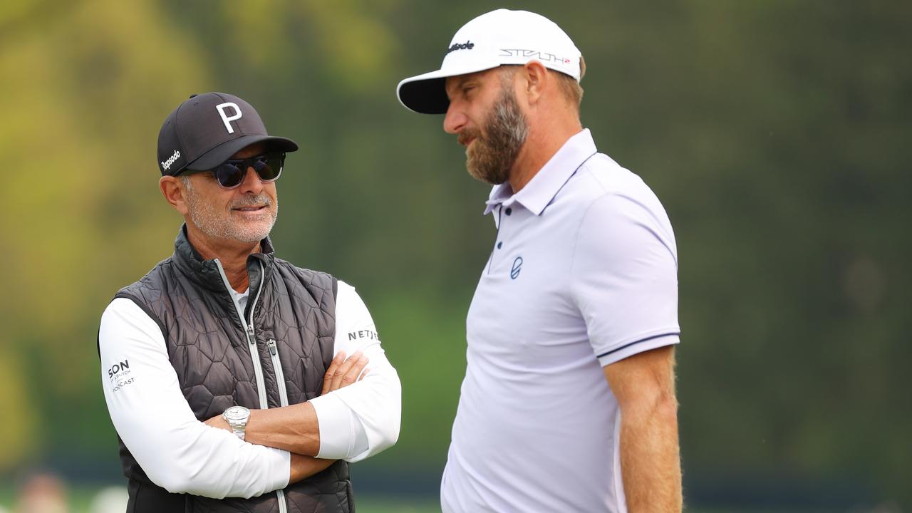 Coach Claude Harmon III talks with Dustin Johnson. Photo by Kevin C. Cox/Getty Images