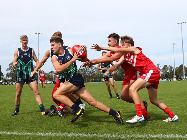 Helensvale (green and blue) do battle with Palm Beach Currumbin (red) in the AFLQ Schools Cup grand final. Picture credit: AFLQ