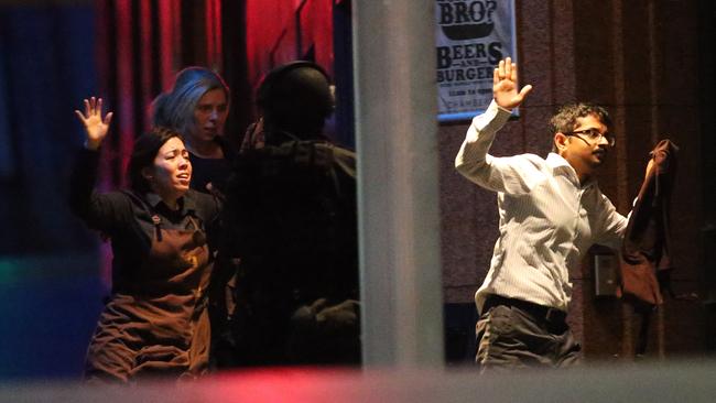 Hostages run to safety during the Lindt cafe siege in Sydney, masterminded by lone wolf terrorist Man Heron Monis, who pledged his allegiance to IS. Picture: AP