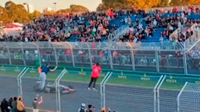 F1 fans climb on fences at Albert Park while cars were still racing. Picture: 7 News