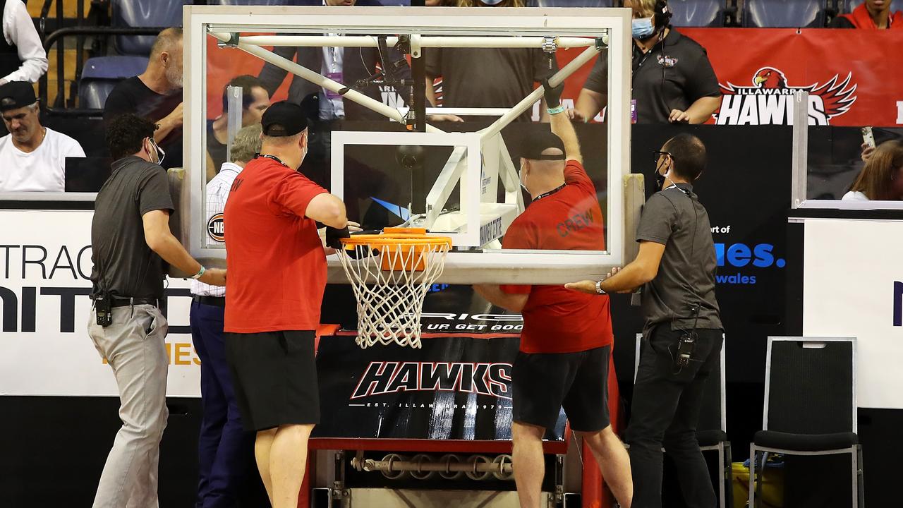 Staff try to fix the backboard and ring after it came down during the warm-up before the round 11 NBL match between the Illawarra Hawks and the Brisbane Bullets. Photo:Getty Images