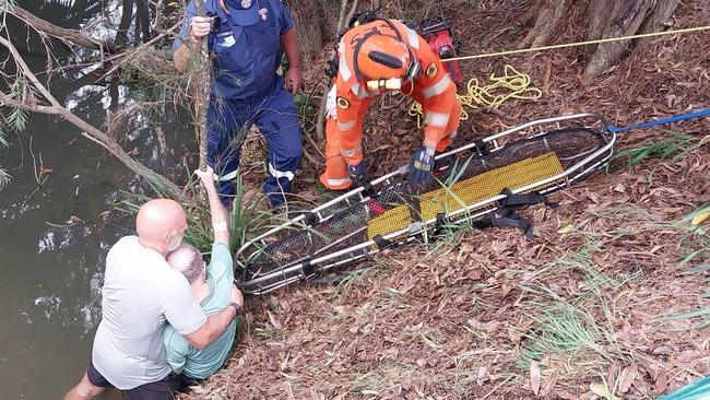 Scott Upston in action rescuing Bob Hood, who fell into Wrights Creek while walking on Shelly Beach Rd on Friday, February 9.