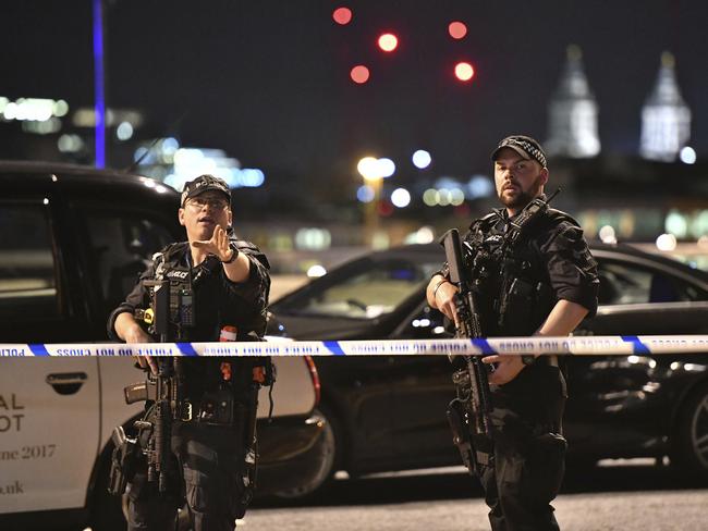 Armed Police officers stand guard on London Bridge in central London. Picture: PA via AP