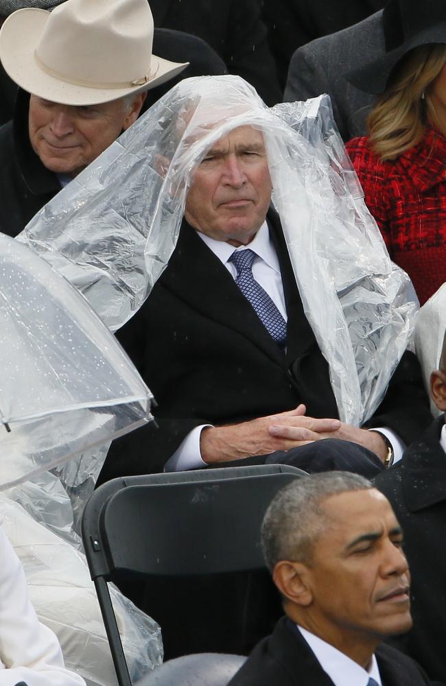 Former President George W. Bush keeps covered under the rain during the inauguration ceremonies swearing in Donald Trump as the 45th president of the United States on the West front of the U.S. Capitol in Washington, U.S on January 20, 2017. Picture: Reuters