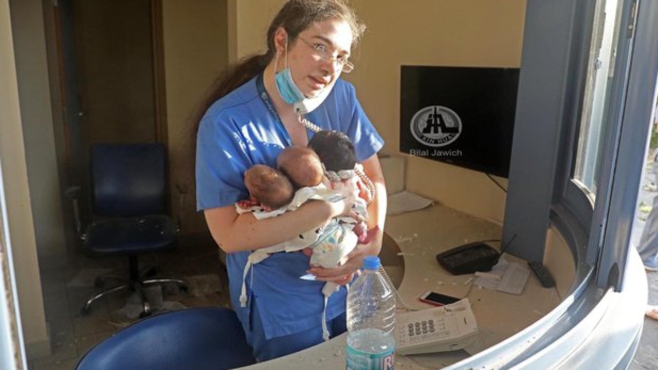 A nurse cradles three babies at a hospital in Beirut following the blast caused by a massive store of ammonium nitrate.