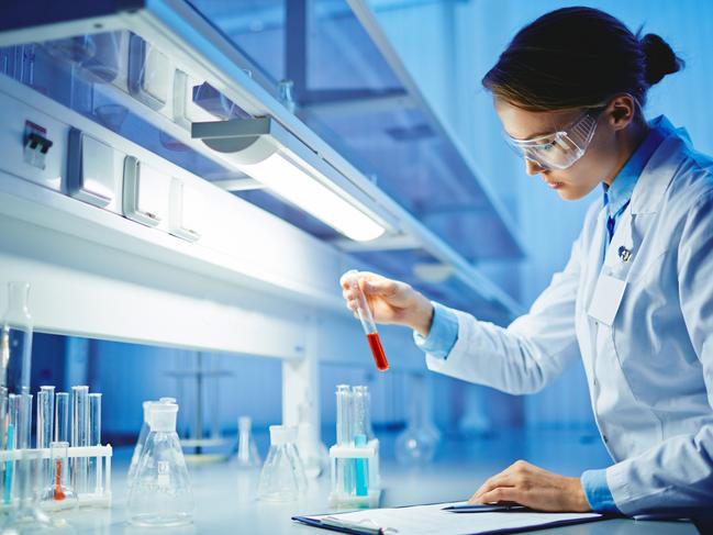 HEALTH:  Young woman working with liquids in glassware. Biotechnology research  laboratory generic