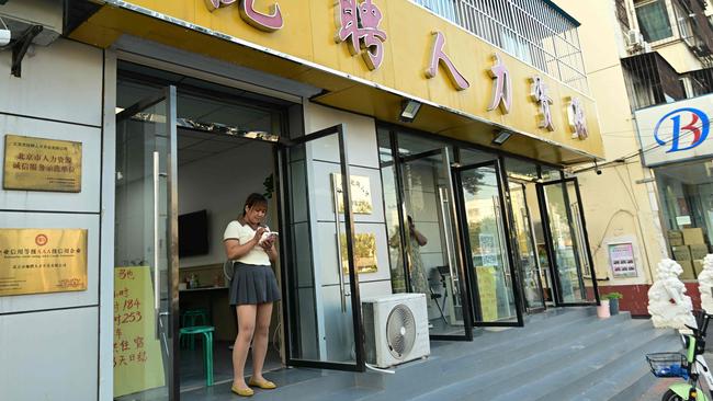 A woman is pictured at the entrance of a job search agency in Beijing. Picture: AFP