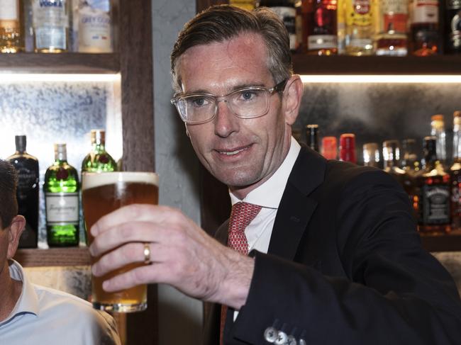 SYDNEY, AUSTRALIA - OCTOBER 11: Premier Dominic Perrottet (R) and Deputy Premier Pail Toole drink a beer before holding a media conference at WatsonÃ¢â¬â¢s Pub in Moore Park  on October 11, 2021 in Sydney, Australia. COVID-19 restrictions have eased across NSW today after the state passed its 70 per cent double vaccination target. Under the state government's Reopening NSW Roadmap, people who are fully vaccinated are permitted to have 10 visitors in their homes, and outdoor gatherings can have up to 20 people. Hospitality, retail stores, gyms and hairdressers can reopen, as well as cinemas, theatres, museums and galleries. Indoor pools are also able to reopen and up to 500 people can attend ticketed outdoor events. Weddings and funerals are permitted to have up to 100 people provided all adults have received two doses of a COVID-19 vaccine. Churches and places of worship can open with no singing. Restrictions will ease further in NSW once the state reaches its next vaccination milestone of 80 per cent of people having received two doses of a COVID-19 vaccine. (Photo by Brook Mitchell/Getty Images)