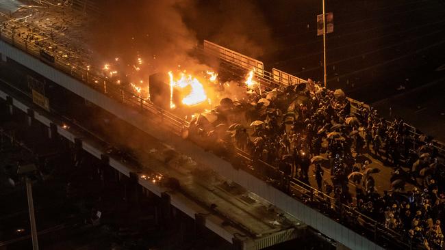 A police personnel vehicle is on fire as protesters throw fire bombs on a bridge at The Hong Kong Poytechnic University on the weekend. Picture: Getty Images