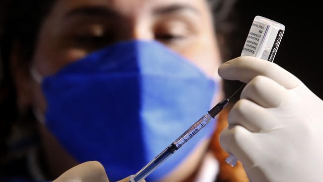 A nurse prepares a booster dose of the AstraZeneca's COVID-19 vaccine for people over 50 years old at a vaccination center set up at the Benito Juarez Auditorium in Zapopan, state of Jalisco, Mexico, on January 24, 2022. (Photo by ULISES RUIZ / AFP)