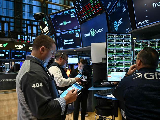 Traders and financial professional work on the floor of the New York Stock Exchange (NYSE) at the opening bell on January 27, 2025 in New York City. European and Asian stock markets mostly slid Monday and Wall Street was forecast to open sharply lower on talk that a cheaper Chinese generative AI programme can outperform big-name rivals, notably in the United States. (Photo by ANGELA WEISS / AFP)