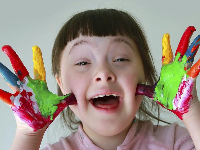 Cute little girl with painted hands. Isolated on grey background.