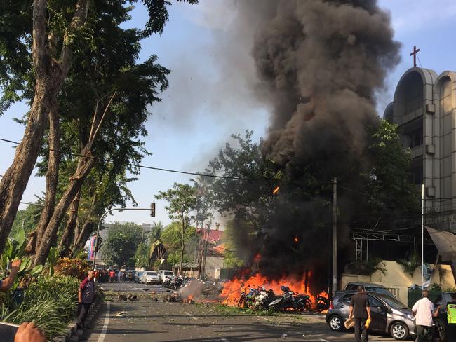 TOPSHOT - This handout photo from the Surabaya local government (Pemerintah Kota Surabaya) taken on May 13, 2018 and received by AFP on May 14, 2018 shows police at the site of a blast outside the Gereja Pantekosta Pusat Surabaya (Surabaya Centre Pentecostal Church) in Surabaya.   A series of blasts, including at least one suicide bombing, struck churches in Indonesia on May 13, killing at least 11 people and wounding dozens in the deadliest attack for years in the world's biggest Muslim-majority country. / AFP PHOTO / PEMERINTAH KOTA SURABAYA / Andy PINARIA / RESTRICTED TO EDITORIAL USE - MANDATORY CREDIT 