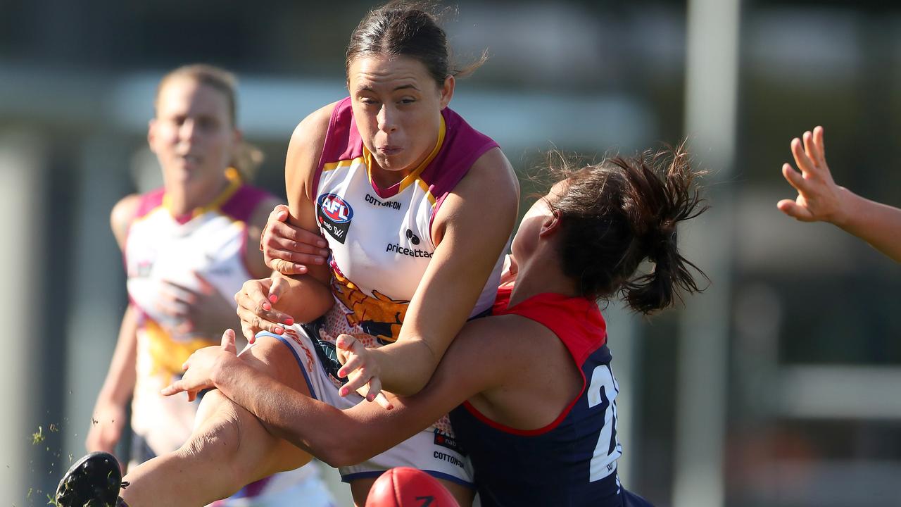 Sophie Conway kicks the ball under pressure from Brenna Tarrant of the Demons.